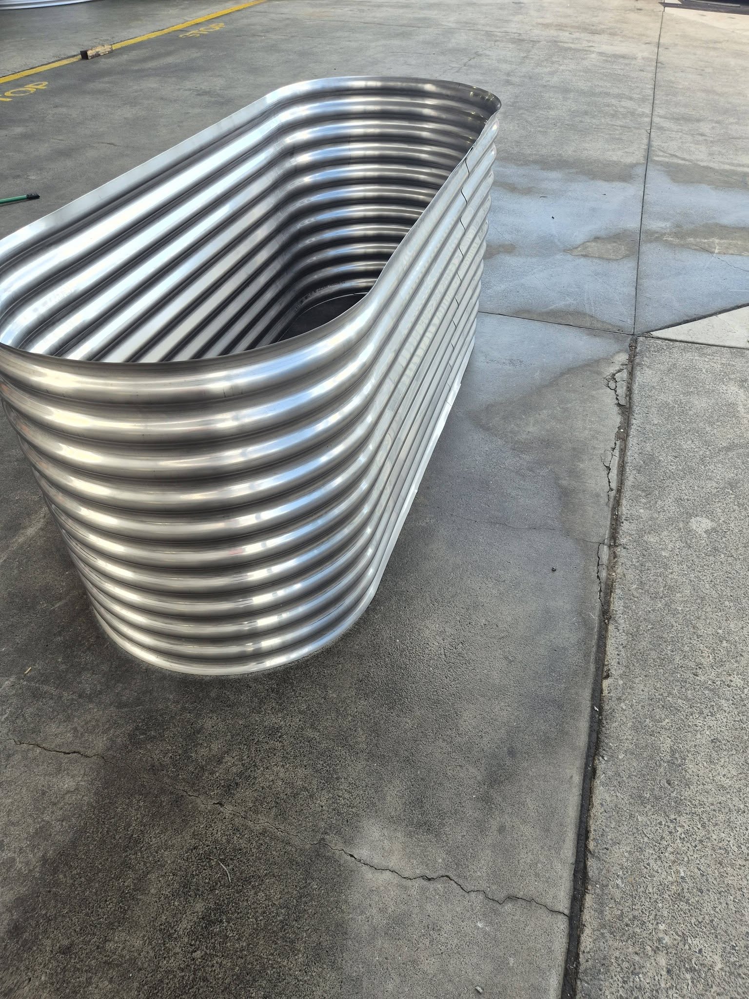 Large stainless steel raised garden bed — close-up of corrugated ridges