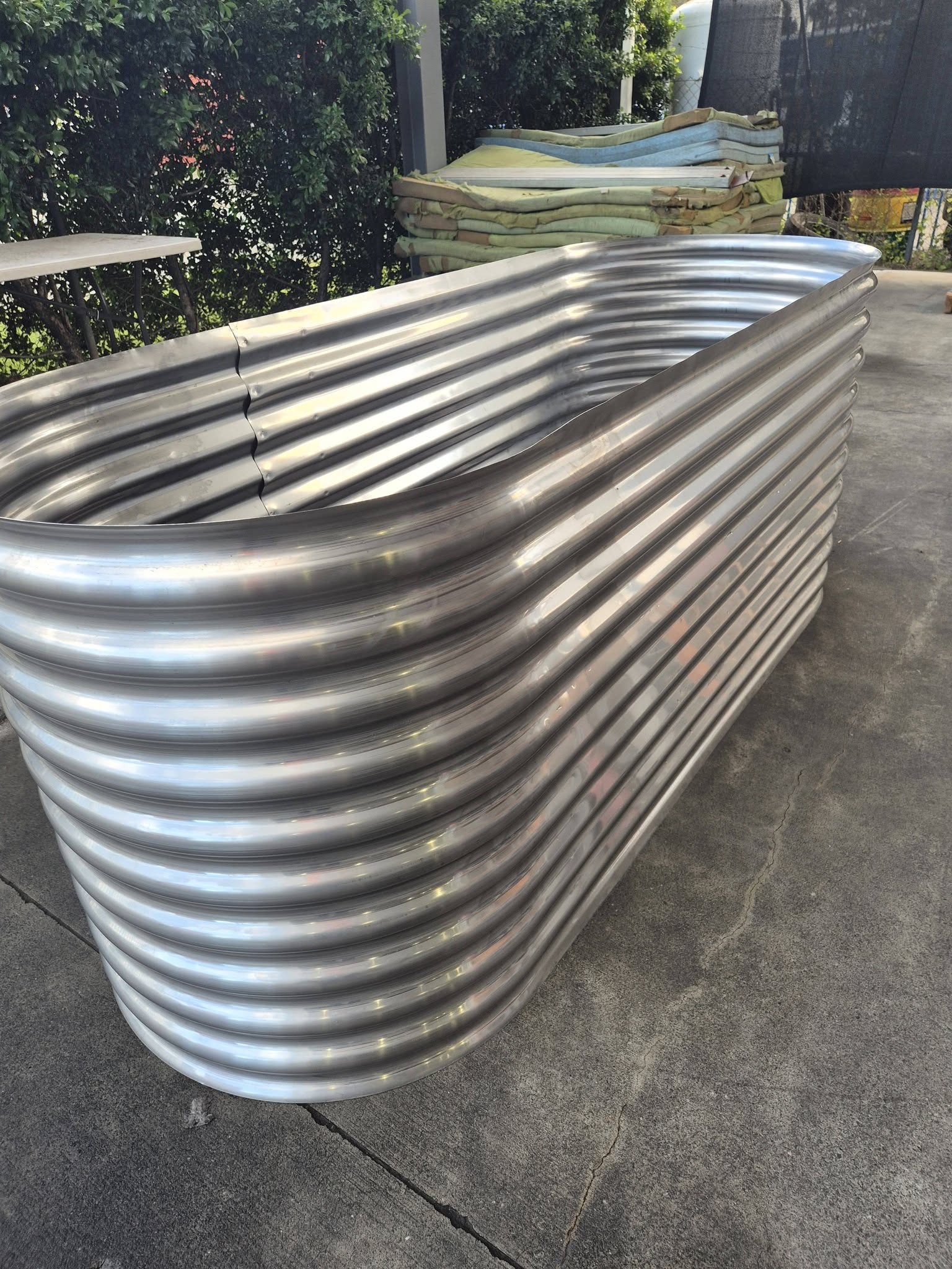 Large stainless steel raised garden bed — full side view showing scale