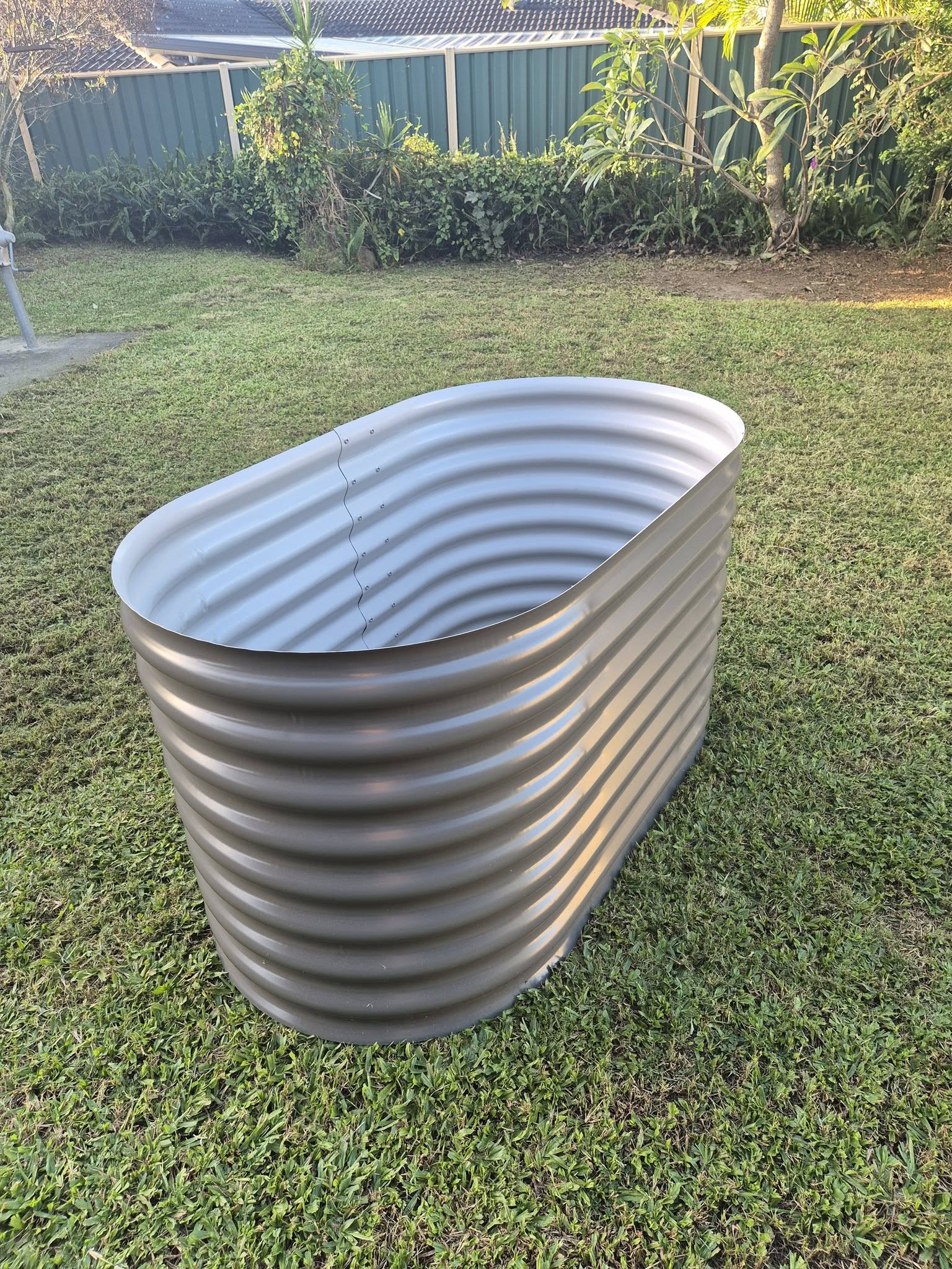 Aquaplate steel woodland grey raised garden bed — angled end view showing oval shape